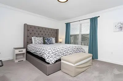 a white bedroom with a bed and a window at Luxurious Home w/ Pool Near Disney in Kissimmee