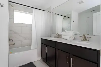 a white bathroom with a sink and a shower at Luxurious Home w/ Pool Near Disney in Kissimmee