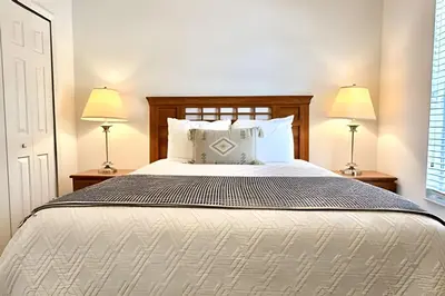 a bedroom with a large bed with two lamps at Bella Vida Resort Pool Home near Disney in Kissimmee