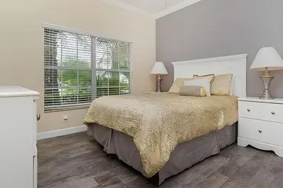 a bedroom with a bed and two lamps and a window at Storey Lake Private Pool Home Near Disney in Kissimmee