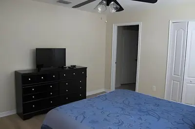 a bedroom with a bed and a tv on a dresser at Storey Lake Private Pool Home Near Disney in Kissimmee