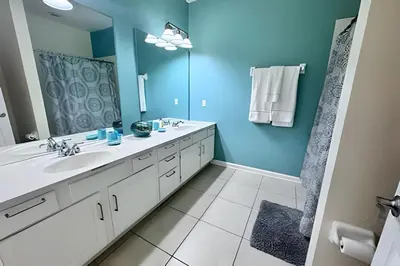 a bathroom with two sinks and a large mirror at Vista Cay Spacious Convention Center/Disney in Orlando