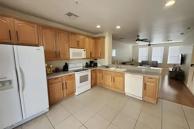 a kitchen with wooden cabinets and a white refrigerator at Vista Cay Spacious Convention Center/Disney in Orlando