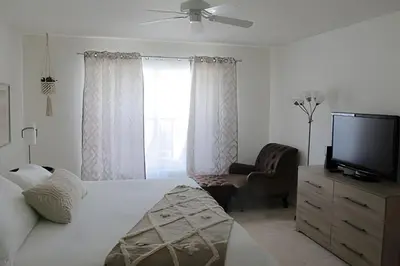 a bedroom with a bed and a tv and a chair at Premium Pool Villa Centrally Located near Disney in Kissimmee