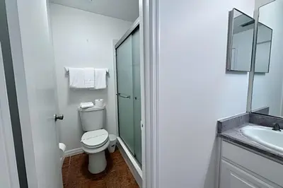 a white bathroom with a toilet and a sink at Corner Lot Pool Home Central Located near Disney in Kissimmee