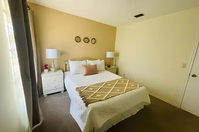 a bedroom with a bed and two lamps and a window at Huge Lot, Private Pool Home Centrally Located in Kissimmee