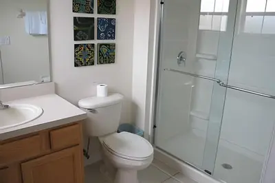 a bathroom with a toilet and a glass shower at Encantada Resort, Pool, close to Disney in Kissimmee