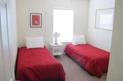 two beds in a white room with red sheets at Encantada Resort, Pool, close to Disney in Kissimmee