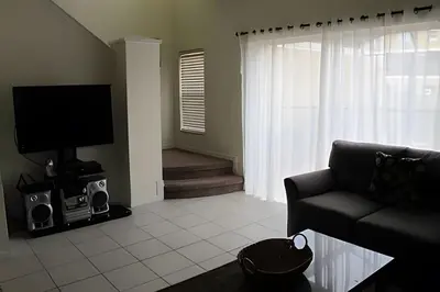 a living room with a couch and a tv at Encantada Resort, Pool, close to Disney in Kissimmee