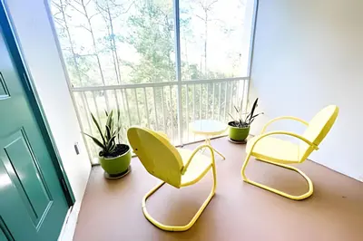 three chairs and a table in a room with a window at Cozy & Bright Condo in Legacy Dunes near Disney in Kissimmee