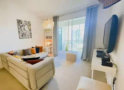 a living room with a couch and a tv at Cozy & Bright Condo in Legacy Dunes near Disney in Kissimmee