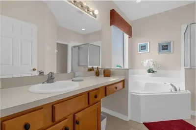 a white bathroom with two sinks and a tub at 2767LKD-Emerald Island Resort home in Kissimmee