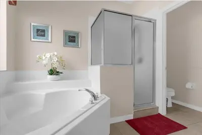 a white bathroom with a tub and a shower at 2767LKD-Emerald Island Resort home in Kissimmee