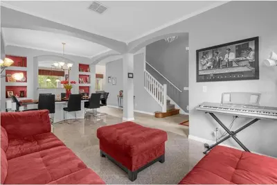 a living room with a red couch and a piano at 2767LKD-Emerald Island Resort home in Kissimmee