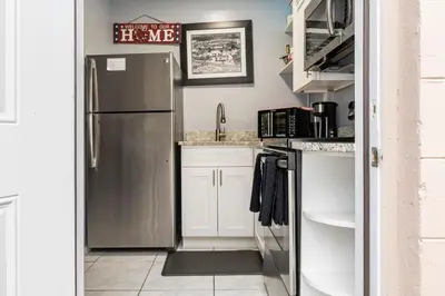 a kitchen with a stainless steel refrigerator and white cabinets at Private 1 Bed 1 Bath Orlando Oasis Shopping and Parks Nearby in Orlando