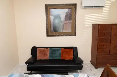 a black leather couch in a room with a painting at Private 1 Bed 1 Bath Orlando Oasis Shopping and Parks Nearby in Orlando