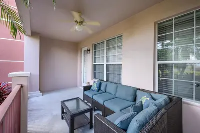 a living room with a blue couch on a porch at Luxury Lakeview, Vista Cay Orlando 1027 in Orlando