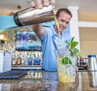 a bartender is pouring a drink into a glass at Penthouse Vacation Condo, Near the Parks - 2015 in Orlando