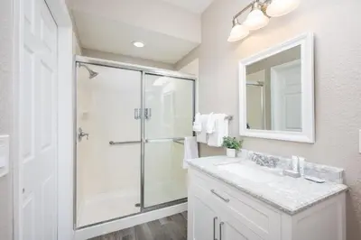 a bathroom with a shower and a sink and a mirror at Beautiful Family Townhome, Near The Parks - 4032 in Orlando