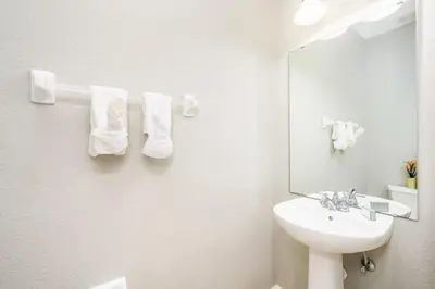 a white bathroom with a sink and a mirror at Beautiful Townhome, Vista Cay, Near Parks - 4018 in Orlando