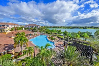 an aerial view of a pool at a resort with a lake at New Gorgeous Townhome, Epic Universe, Vista Cay - 4008 in Orlando