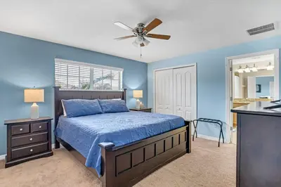 a bedroom with a bed and a ceiling fan at Cozy Retreat-Heated Pool, Grill, Pickle Ball, Gym in Kissimmee