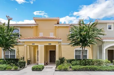a house with trees in front of it at Cozy Retreat-Heated Pool, Grill, Pickle Ball, Gym in Kissimmee