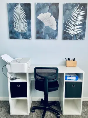 a desk with a chair and three pictures on the wall at Cozy Retreat-Heated Pool, Grill, Pickle Ball, Gym in Kissimmee