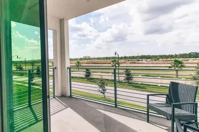 a balcony with two chairs and a view of a field at Conforto e Lazer a 7km da Disney – 2 Quartos in Kissimmee