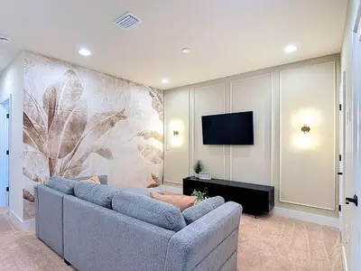a living room with a blue couch and a tv at Spacious 3BR with Clubhouses and Splash Fun in Orlando