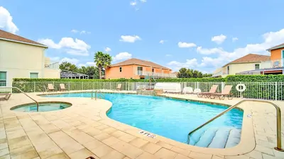 a swimming pool with chairs and a fence at Spacious 3BR with Clubhouses and Splash Fun in Orlando