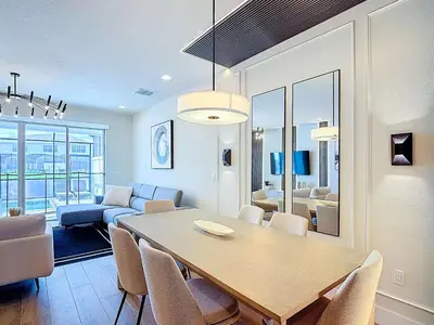 a dining room and living room with a table and chairs at Spacious 3BR with Clubhouses and Splash Fun in Orlando