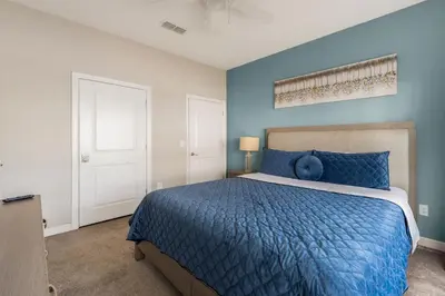 a bedroom with blue walls and a bed with a blue comforter at Relax Near Disney 4BR Home with Pool in Kissimmee