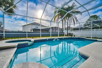 a swimming pool with blue water and palm trees at Bay Pointe Pool Home Near Parks in Kissimmee