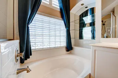 a white tub in a bathroom with a window at Bay Pointe Pool Home Near Parks in Kissimmee