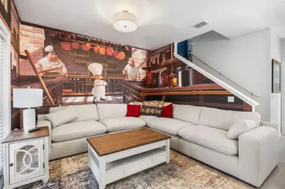 a living room with a couch and a kitchen at 4BR Themed Home W Resort Pool Near Disney in Kissimmee