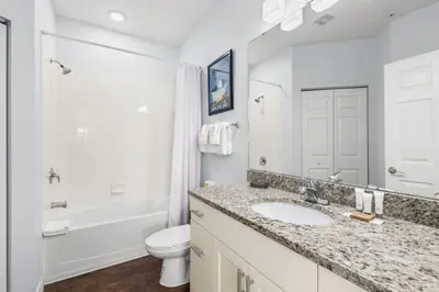 a white bathroom with a sink and a toilet at 4BR Themed Home W Resort Pool Near Disney in Kissimmee