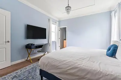 a bedroom with a bed and a desk and a television at Lakefront 5BR Family Resort Pool Home Near Disney in Kissimmee