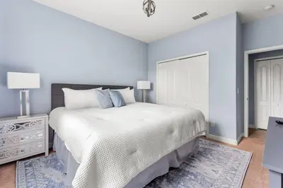 a bedroom with a large white bed and a door at Lakefront 5BR Family Resort Pool Home Near Disney in Kissimmee