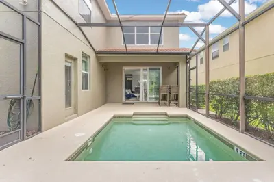 a swimming pool in the backyard of a house at Lakefront 5BR Family Resort Pool Home Near Disney in Kissimmee