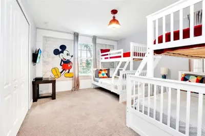 a childs room with a mickey mouse mural on the wall at Lakefront 5BR Family Resort Pool Home Near Disney in Kissimmee