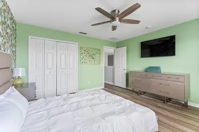 a bedroom with green walls and a bed with a ceiling fan at Fantastic 5BR Themed Pool Home Near Disney World in Kissimmee