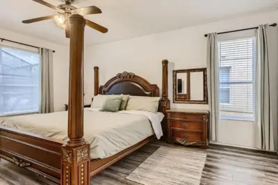 a bedroom with a bed and a fan and a dresser at Magical 7BR Resort Pool Home Near Disney World in Kissimmee