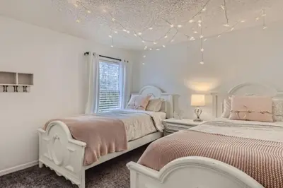 a white bedroom with two beds and a window at Magical 7BR Resort Pool Home Near Disney World in Kissimmee