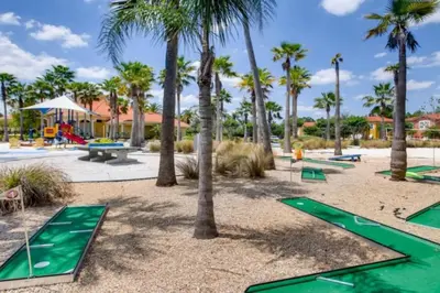 a playground with trampolines and palm trees at Magical 7BR Resort Pool Home Near Disney World in Kissimmee