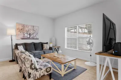 a living room with a couch and a table at 4BR Townhome with Pool at Storey Lake in Kissimmee