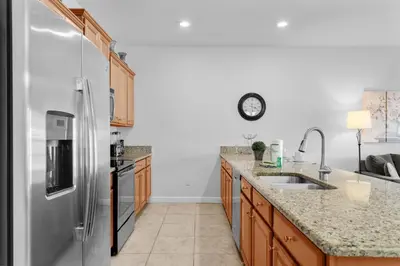 a kitchen with a refrigerator and a sink at 4BR Townhome with Pool at Storey Lake in Kissimmee