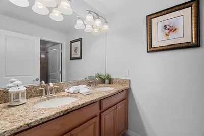 a bathroom with two sinks and a large mirror at 4BR Townhome with Pool at Storey Lake in Kissimmee
