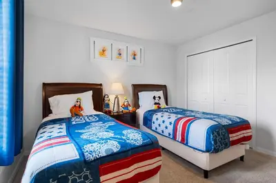 a bedroom with two beds and toys on a table at 4BR Townhome with Pool at Storey Lake in Kissimmee