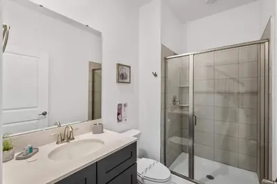 a bathroom with a toilet and a sink and a shower at Stylish Family Retreat with Themed Bedrooms in Kissimmee